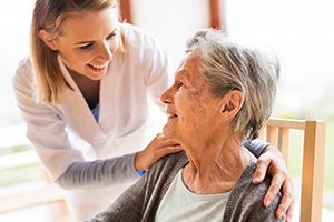 nurse helping elderly woman 